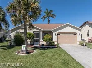 Single story home featuring a front yard, concrete driveway, and a garage
