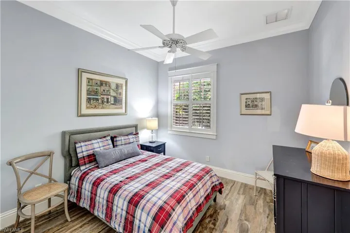 Bedroom with ornamental molding, light wood-style flooring, and ceiling fan