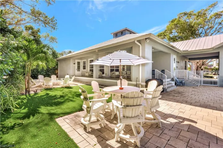 Back of property with a patio, stucco siding, a metal roof, and outdoor dining area