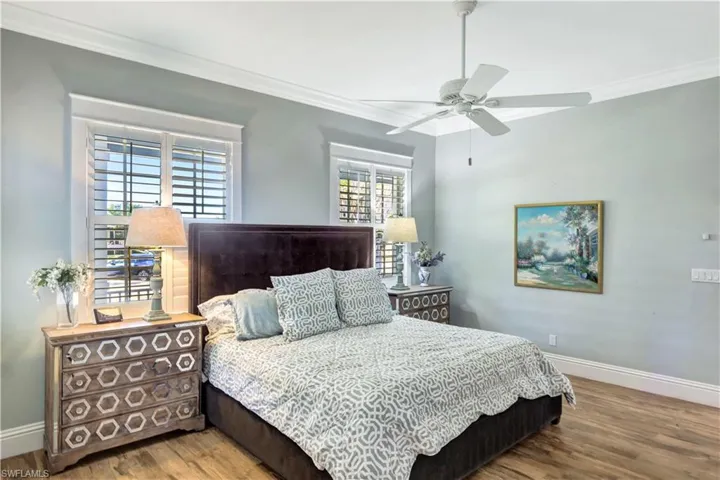 Bedroom with wood inspired tile finished floors, ornamental molding, and a ceiling fan