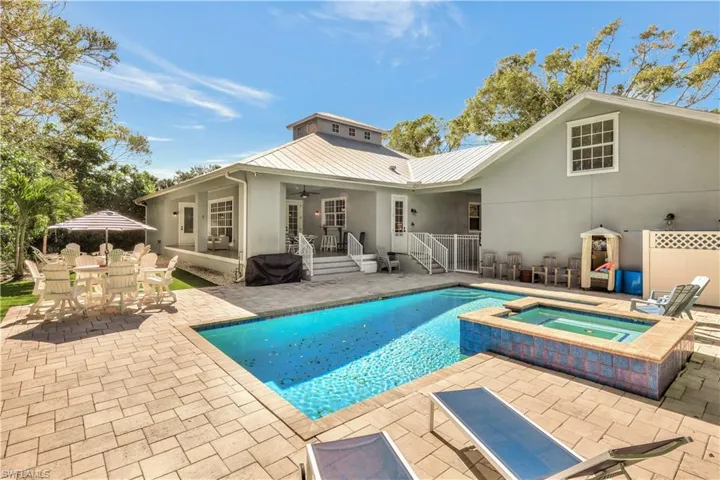 View of swimming pool with a patio, a pool with connected hot tub, and outdoor dining space