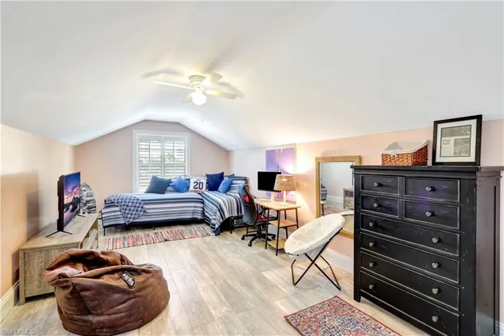 Game room with light wood inspired tile floors, & vaulted ceiling