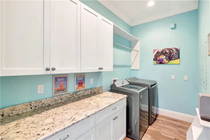 Laundry area with ample storage, washing machine and clothes dryer, and space for hang drying clothes