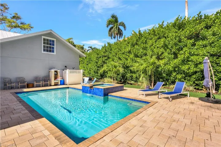 View of swimming pool with a patio area and a pool with connected hot tub