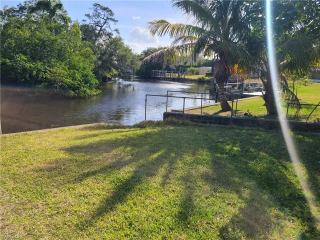 Dock area with a lawn and a water view