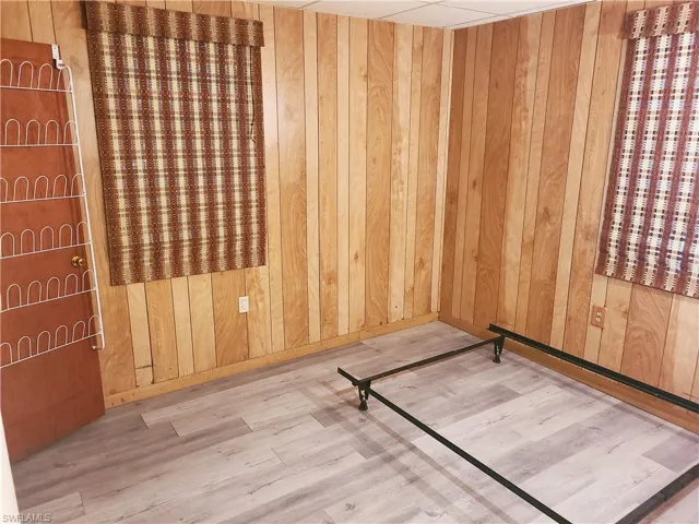 Unfurnished room with wood walls and wood finished floors