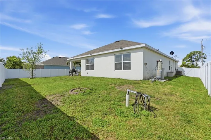 Back of house with a fenced backyard and stucco siding