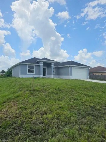View of front of house featuring a front lawn and a garage