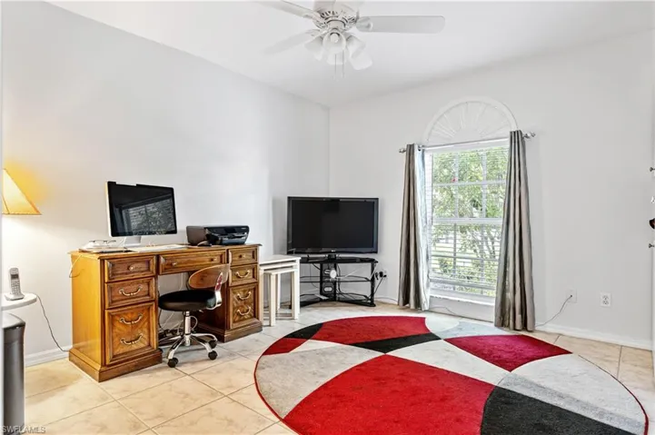 Office area with light tile patterned flooring and a ceiling fan