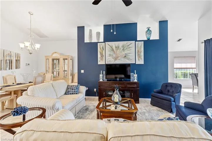 Living area with a chandelier, a ceiling fan, and a towering ceiling