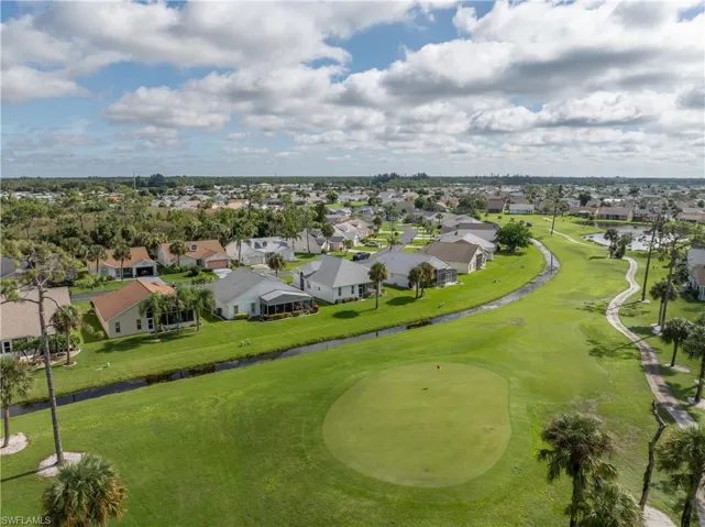 Aerial perspective of suburban area with a nearby body of water and a golf course