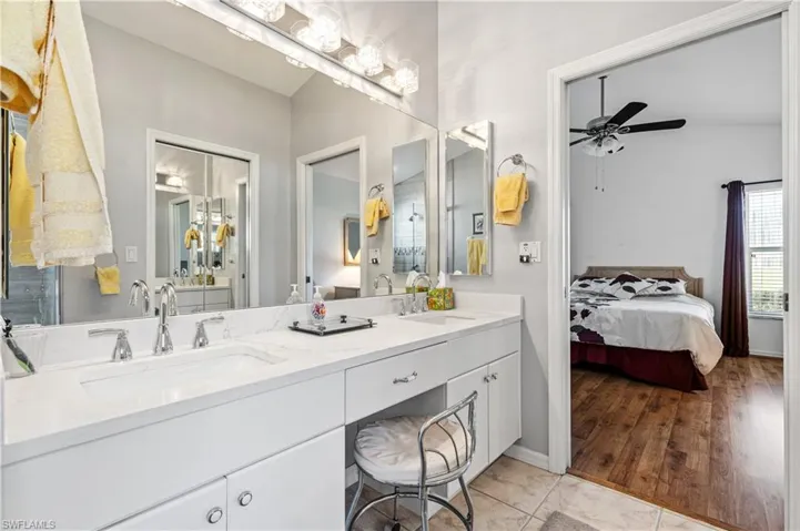Bathroom featuring double vanity, a ceiling fan, ensuite bathroom, and light tile patterned floors