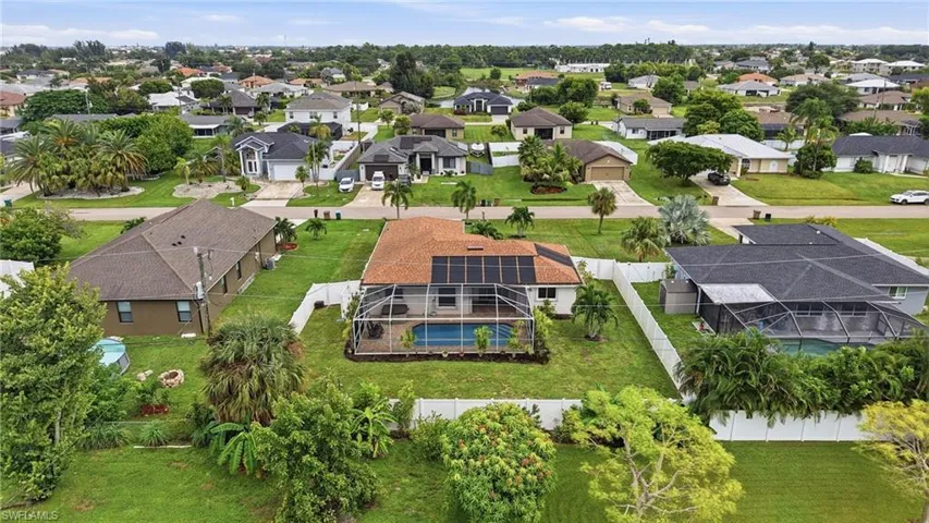 Exterior featuring a screened-in pool, solar panels, and a brown shingle roof