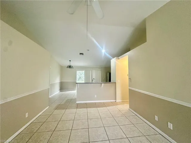 Spare room featuring light tile patterned floors, baseboards, visible vents, and a ceiling fan
