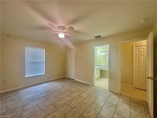Unfurnished room with baseboards, visible vents, and a ceiling fan