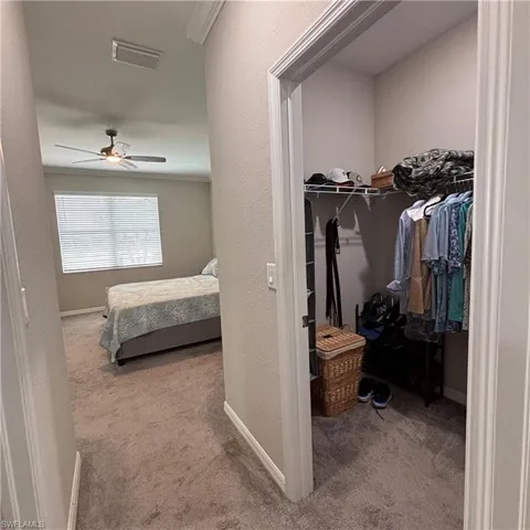 Bedroom with light carpet and ceiling fan