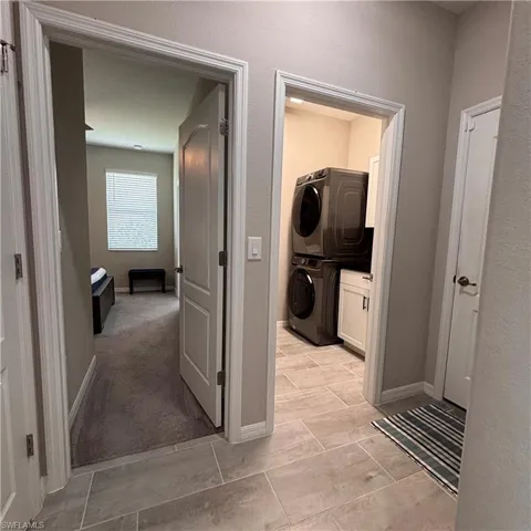 Laundry room with cabinet space and stacked washer / dryer