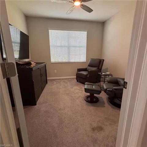 Sitting room featuring light colored carpet and ceiling fan