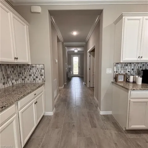 Corridor featuring crown molding and wood tiled floors