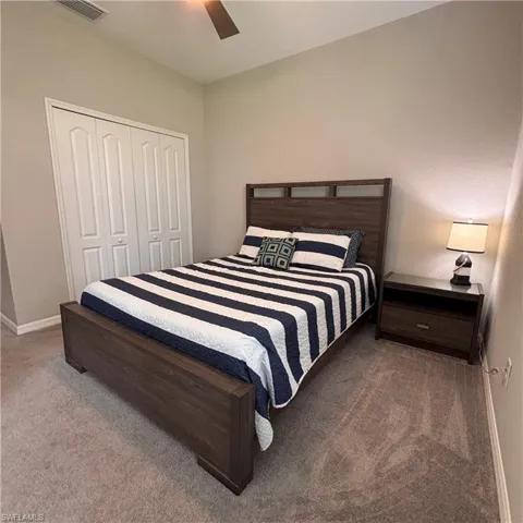 Bedroom featuring carpet flooring, a closet, and a ceiling fan