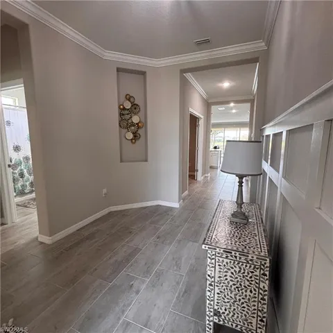 Hallway featuring ornamental molding and wood tiled floors