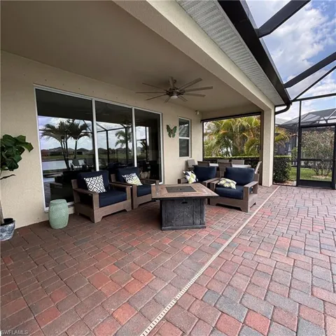 View of patio / terrace with an outdoor living space with a fire pit, a sunroom, glass enclosure, and a ceiling fan