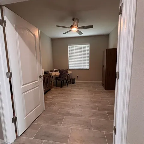 Living area with a ceiling fan, wood tiled floors, and an office area