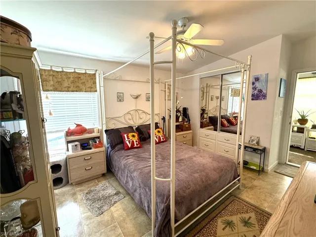 Bedroom with ceiling fan, a closet, and light tile patterned floors
