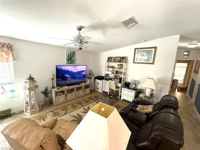 Living room featuring ceiling fan, lofted ceiling, and an office area