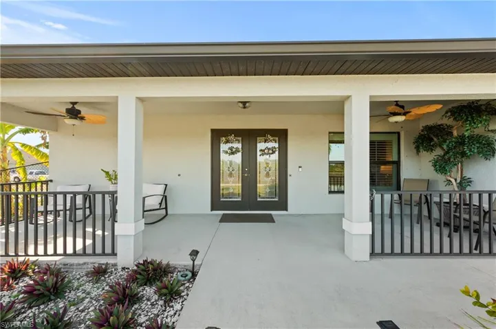 Property entrance with ceiling fan and stucco siding