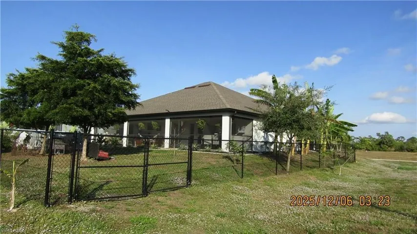 Rear view of house with a gate and a sunroom