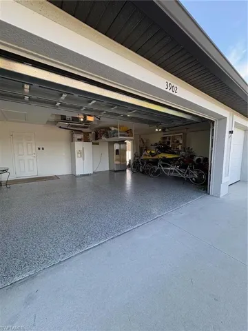 Garage featuring white fridge with ice dispenser and built in refrigerator
