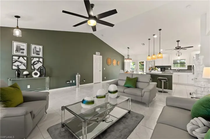 Living room with a ceiling fan and vaulted ceiling