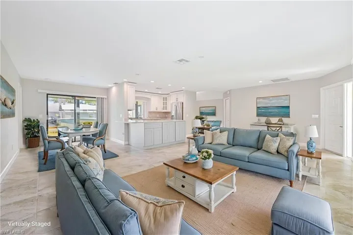 Open-concept living space featuring neutral tone tile flooring and light-toned walls