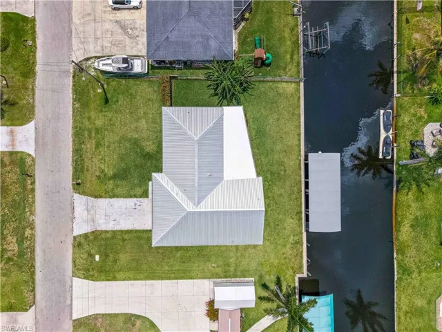 Waterfront property featuring a private boat dock, concrete seawall, and direct canal access