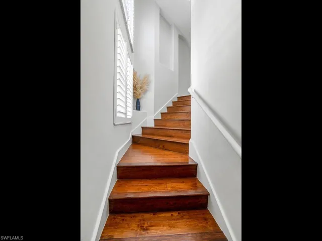 Staircase featuring hardwood / wood-style floors and baseboards