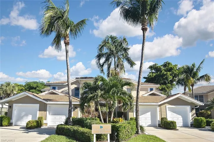 View of front of property with stucco siding, driveway, and a tiled roof