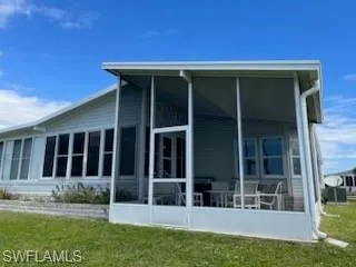 View of property exterior featuring a sunroom and a yard
