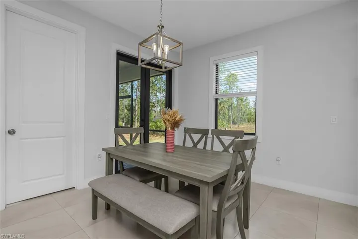 This dining area features light-colored walls and tiled flooring