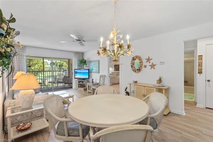 Dining room with light wood-style floors, hanging lights, and a ceiling fan