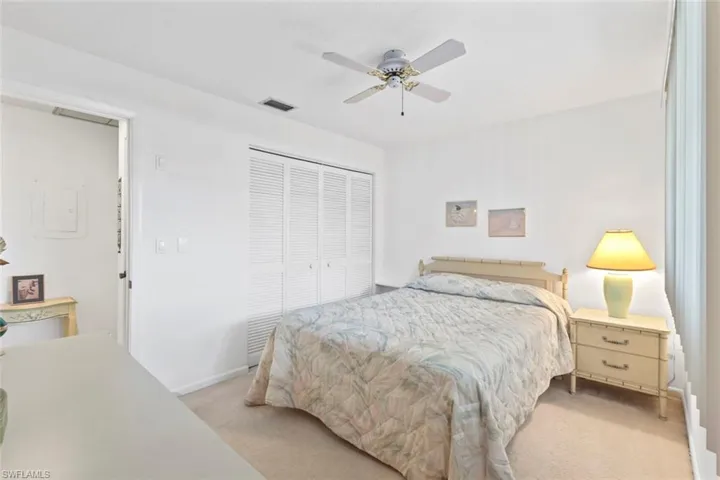 Bedroom with light carpet, a closet, and ceiling fan
