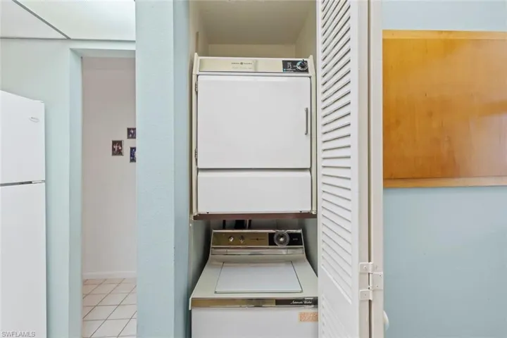 Laundry area featuring stacked washer / dryer and light tile patterned floors