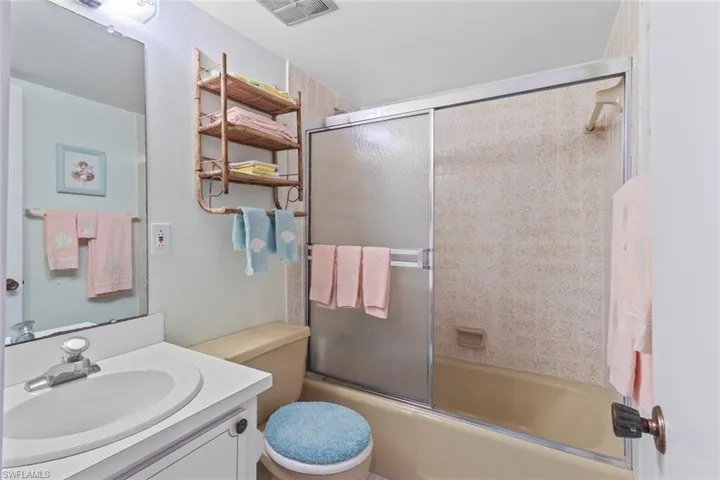 Full bath featuring vanity and combined bath / shower with glass door