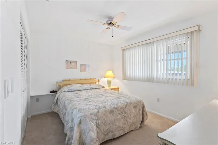 Carpeted bedroom featuring a closet and a ceiling fan