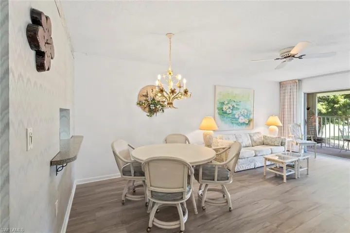Dining room with wood finished floors, a ceiling fan, and suspended lighting