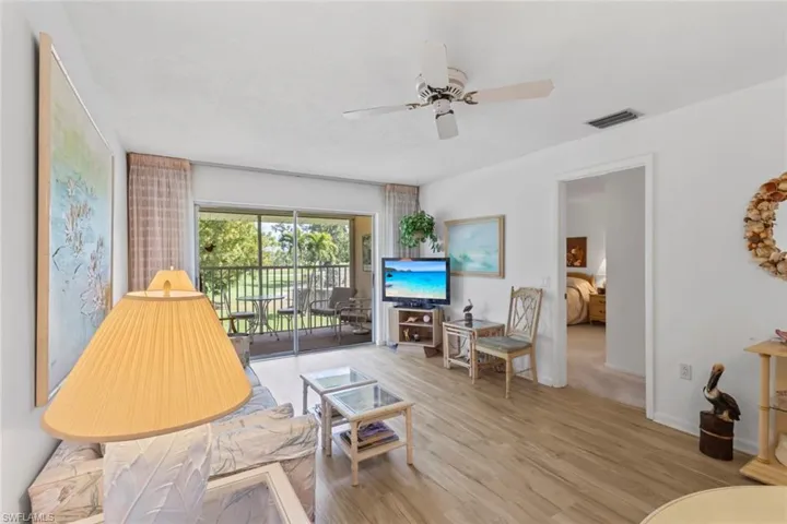 Living room with light wood-type flooring and ceiling fan