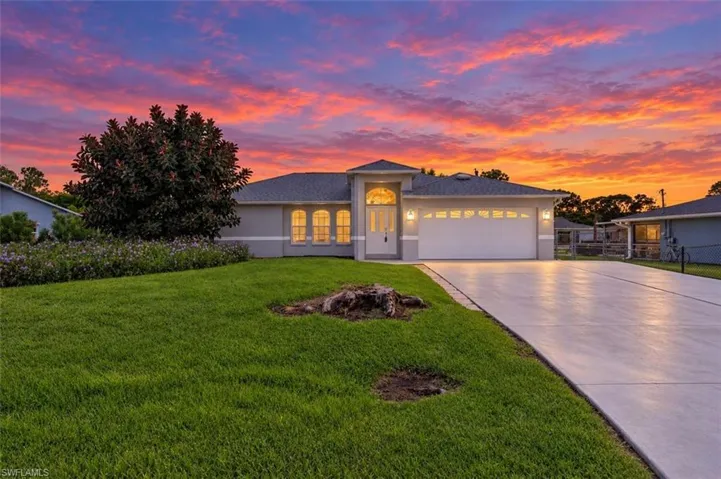Contemporary exterior with a two-car garage, concrete driveway, and manicured lawn