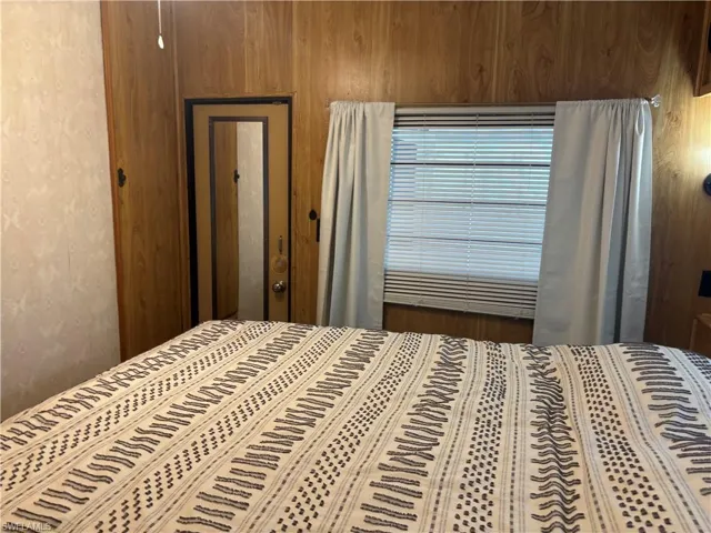 Bedroom featuring wood walls