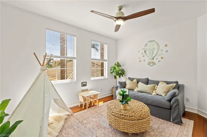 Living room with baseboards, wood finished floors, and a ceiling fan