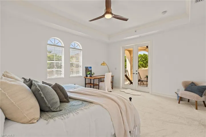 Bedroom featuring carpet floors, access to exterior, french doors, and a raised ceiling